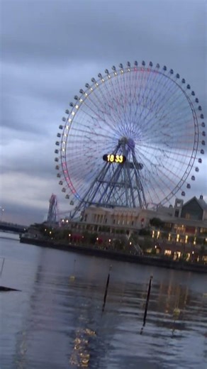 夕暮れのみなとみらいの運河から見た観覧車「コスモクロック21」のライトアップ開始