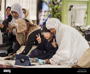 Bangkok, Thailand. 6th July, 2016. A family uses a tablet computer to record video before Eid services at Ton Son Mosque in the Thonburi section of Bangkok. Eid al-Fitr is also called Feast of Breaking the Fast, the Sugar Feast, Bayram (Bajram), the Sweet Festival or Hari Raya Puasa and the Lesser Eid. It is an important Muslim religious holiday that marks the end of Ramadan, the Isic holy month of fasting. Muslims are not allowed to fast on Eid. l Credit:  ZUMA Press, Inc./Alamy Live News Stock