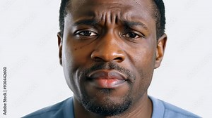 Middle-aged African American man staring into camera with sad expression