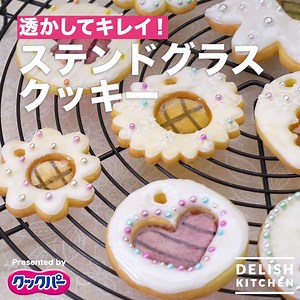 透けるヒミツはカラフルキャンディー！ステンドグラスクッキーのご紹介です♪ おうち時間が増えるこの時期、クックパー®でスイーツ作りはいかが？ 溶かしたキャンディーもくっつかずサラッとはがれるので、キレイに仕上がりますよ！ お子様と一緒にデコレーションも楽しめます♪ [Presented by クックパー®] ■材料 (直径5cm 約15枚分) 【クッキー生地】 ・バター（食塩不使用） 60g ・砂糖 40g ・とき卵 大さじ1と1/2 ・薄力粉 100g ※このほか、クッキー生地のくっつき防止用の打ち粉として、強力粉を使用します。 【ガラス部分: 飴】 ・フルーツドロップなど 40g~50g ■手順 1. 飴は、キッチンバサミなどで3～4mm角に砕く。 2. ボウルに室温に戻したバターを入れてクリーム状に練り、砂糖を加え、白っぽくなるまですり混ぜる。とき卵を少しずつ加えてそのつどよく混ぜる。 3. ふるった薄力粉を加え、粉っぽさがなくなるまでゴムべらでさっくりと混ぜる。ひとまとめにして「サランラップ®」で包み、冷蔵室で1時間以上休ませる。 4. のし板に打ち粉（強力粉:分量外）をふり、「