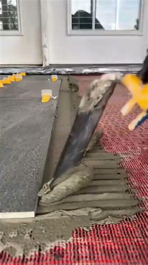 a worker makes a floor with fast setting plaster adhesive