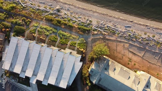 Birdseye drone view of Semiahmoo, Washington harbor with boats on calm sea, scenic shoreline, and iconic water tower at sunset.