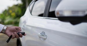 Download Man hand using remote key. Locking the car by the car key remote control. Pressing the button of the car key and the lights blink when door open or closed. for free