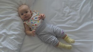 Baby girl moving around on a bed - Free Stock Video