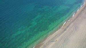 Flying over a peaceful and sunny beach - Free Stock Video