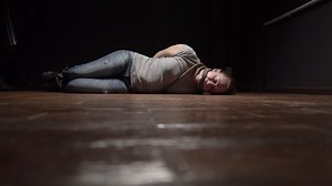 killer approaches victim lying on floor and threatens with gun.