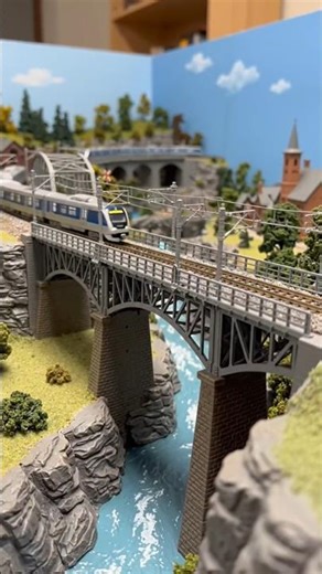 Train on a Bridge in a Rail Model Room by AI