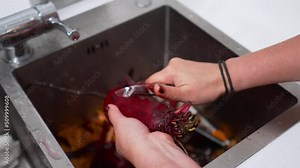 The cook cleans fresh beets with a special knife in an iron sink in the restaurant kitchen. Cooking in a restaurant.