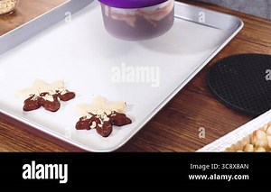 Preparing star-shaped cookies, half-dipped in chocolate, accented with peppermint chocolate chips for the holidays.