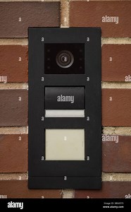 Modern black intercom panel with video surveillance camera, speaker, and nameplate slot mounted on red brick wall Stock Photo - Alamy