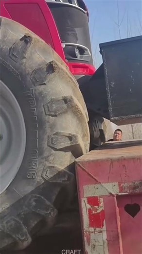 Tire-Driven View: Farm Machinery Loading on Trailer
