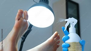 Slow motion - pedicure master sprays lotion on women's feet with a dispenser, moisturized and impregnated for further processing