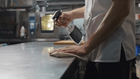 clip-3973284737-slow-motion-close-up-chef-sanitizing-kitchen-workspace-spraying