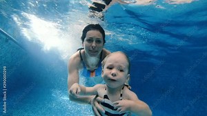 Swimming pool. Mom dives with her baby under the pool water. Stock Video