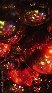A close up of a bunch of colorful disco balls. The balls are all different sizes and colors, and they are all reflecting light. The scene has a fun and energetic vibe. Stock Video
