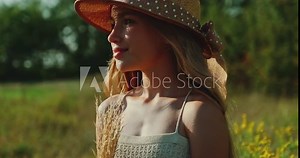 Portrait beautiful cheerful preteen girl smiling at camera. Child in straw hat is in the field at Sunny Day. Slow motion. Gimbal short