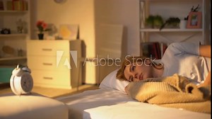 Pretty female looking at alarm clock near bed, getting late work, morning stress