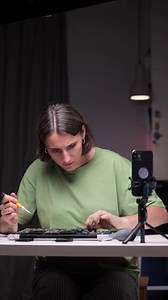 vertical Woman repairing laptop. Girl watches computer repair lesson