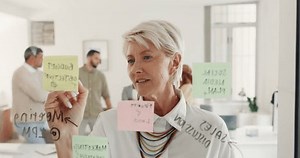 Corporate woman, sticky note writing and glass in planning, target or goals for ideas, brainstorming or mission. Senior executive, seo startup or thinking by wall for strategy, idea or company vision