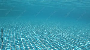 diving under of transparent blue water in swimming pool, close up 4K motion scene