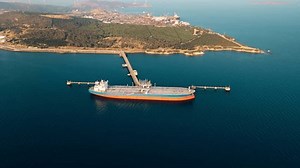 Crude oil tanker ship carrier loading in petrochemical terminal platform dock, Aerial establishing shot