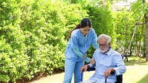 Home care. disabled old man with walker at home. Professional caregiver nursing home. Nurse assisting senior patient at nursing home.