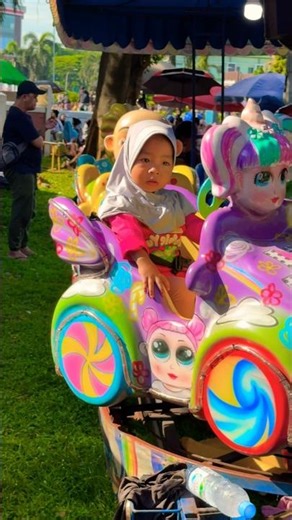 Little sister wearing a headscarf riding a Lol Surprise doll character odong-odong