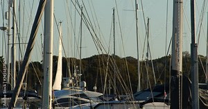 shot of yacht masts at Lymington harbour with boat sailing past in background at Lymington Marina