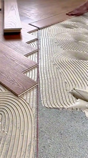 efficient wooden floor installation activity using specialized glue and tiles to create patterns