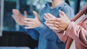 Download Two people clapping in front of a computer screen for free