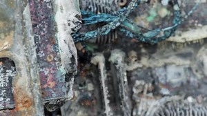 Closeup handheld shot of a burned desktop computer. Scorched computer parts, melted wires. Burned and melted motherboard, and back of the computer with USB ports.
