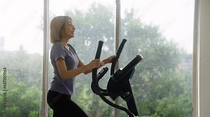 woman in sportswear exercising on an exercise bike at home