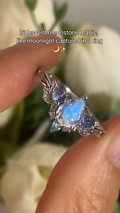 Moonlight on your finger ✨ This rainbow moonstone ring glows with an iridescent blue flash, framed by dreamy tanzanite and delicate leaf details – perfect for the fairy bride who wants a magical, non-traditional engagement ring. 💍🌙 #moonstone #moonstonering #moonstoneengagementring #fairyring #elvenring #natureinspiredjewelry | Azura Jewelry