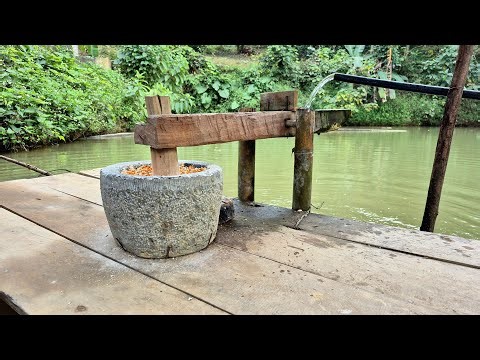 Stone mortar and pestle for grinding corn using water power.