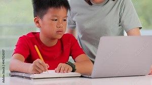 Mother helping her 10 year old son with his homework.
