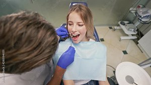 Attractive blond woman sitting in chair while having dental procedure with dentist at the dental clinic Stock Video