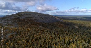 Luostotunturi fell in Lapland, Aerial, reverse, drone shot, away from Luosto bare mountain and autumn color forest, surrounded by endless arctic wilderness, in Pyha-luosto national park, Finland