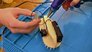 Developing scientific technical creativity of children. A child designs a moving toy car. Little girl working on project with electric toys and robots.