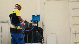 Proficient worker calibrating set of barometer indicators during comissioned condenser analysis. Qualified electrician looking for potential high pressure in hvac system cooling system