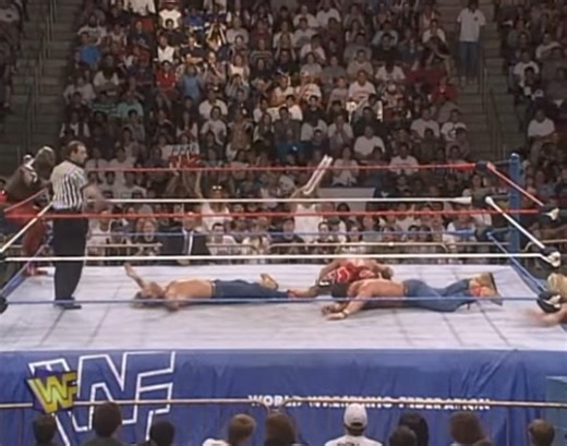 On July 22, 1996 WWF Monday Night Raw aired on the USA Network from the Key Arena in Seattle, Washington. In the main event, The Smoking Gunns (Billy & Bart Gunn with Sunny) put their WWF Tag Team Championship on the line against WWF World Heavyweight Champion Shawn Michaels (on his 31st birthday) and WWF Intercontinental Champion Ahmed Johnson. During the match Faarooq Asad (Ron Simmons) makes his WWF debut attacking Johnson. During the attack by Faarooq, Johnson was injured and had to vacate t