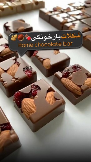 ‎لیمبو |باریستا | آموزش دسر و شیرینی | قنادی | بابل تی🧋‎ on Instagram‎: "برای دریافت رسپی کلمه ( شکلات خونگی ) رو کامنت کن😍👇🏽🍫 اگه می‌خواین مهمونات رو با یه چیز ساده، شیک و واقعاً خوشمزه غافلگیر کنید… این شکلاتای خونگی رو از دست ندین! 😍🍫 هم سالمه، هم سریع درست میشه، هم با مغزیجات و میوه‌خشک‌ها می‌تونید هزار مدل طعم بسازید. نتیجه‌ش؟ یه اسنک حرفه‌ای که هرکی ببینه مطمئن میشه از شیرینی‌فروشی خریدی! 🤌✨ من توی این ویدیو دقیق نشون دادم چطوری با یه قالب ساده، همه‌ی شیارها رو با مغزیجات خوش‌طعم پ