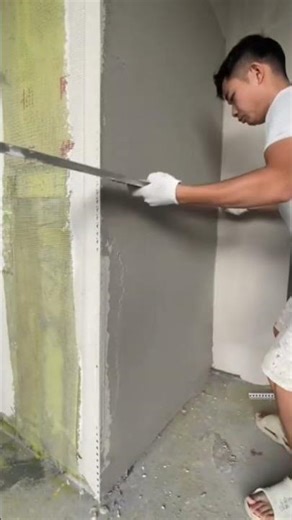leveling and smoothing fresh wall plaster using a long straight edge