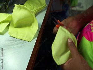 Woman hands using the sewing machine to sew the face medical mask during the coronavirus pandemia. Home made diy protective mask against virus.