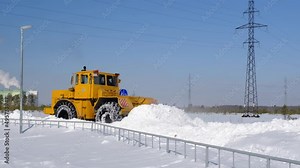 Snow removal. A large tractor clears the road after a heavy snowfall.