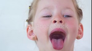 little girl show tongue, throat. portrait with wide open mouth and protruding tongue. with clear view pulls out long tongue. soft palate and mouth to dentist. mouth is wide open, tongue is stuck out.