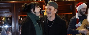 Watch U2’s Bono Sing Rocking Classic Holiday Tune with Imelda May at Annual Christmas Eve Charity Busking Event in Dublin