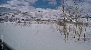 View outside of window from flamsbana train on snow landscape with moutains in the back