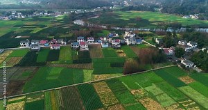 Aerial Chinese countryside landscape in early spring green farm land around the village house beautiful rural view of agriculture filed and farmer building in Sichuan China