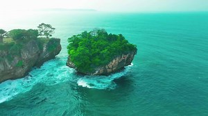 aerial top view of waves break on rocks in a blue ocean. sea waves on beautiful beach aerial view drone. bird's eye view of ocean waves crashing against an empty stone rock cliff from above