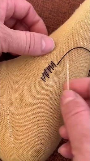 the process of sewing holes in socks manually using your hands